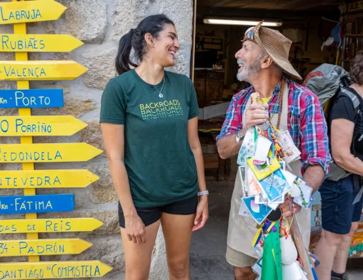 Man and woman smiling next to yellow and blue arrow signs