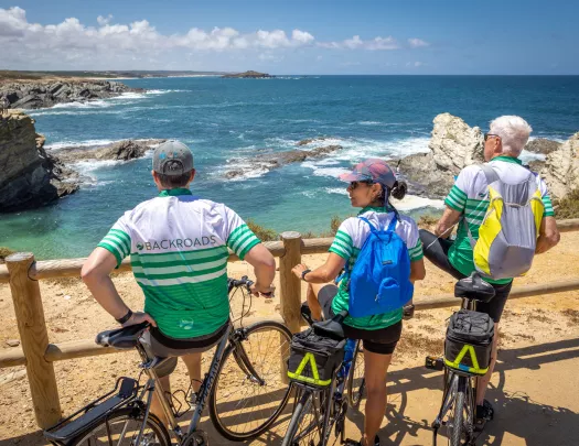 Group of bikers leaning on railings, looking out towards the ocean