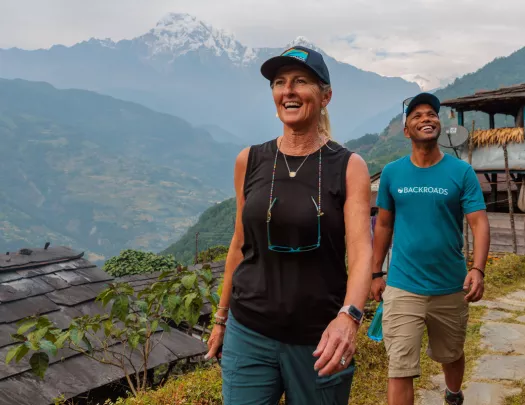 Man and woman smiling while walking on a dirt trail