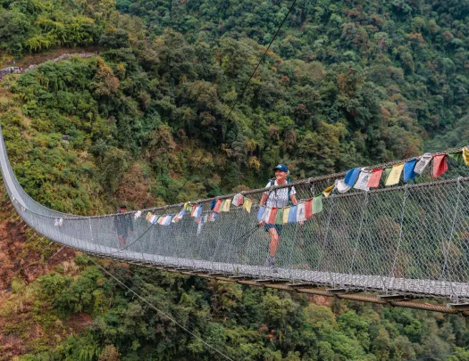 Long, wooden bridge with a woman smiling while walking across