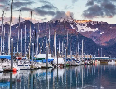 Shot of boat line at pier during sunset, mountain in distance.