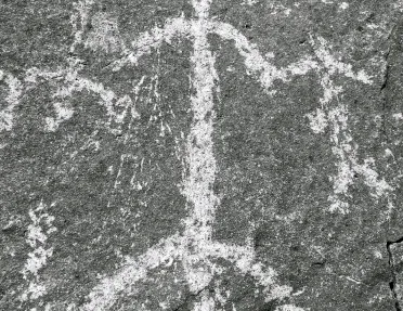 Shot of rock etching, human forms.