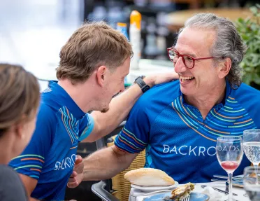 Backroads guests at a meal in their jerseys after a bike ride.