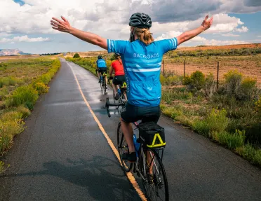 Back shot biker with arms up