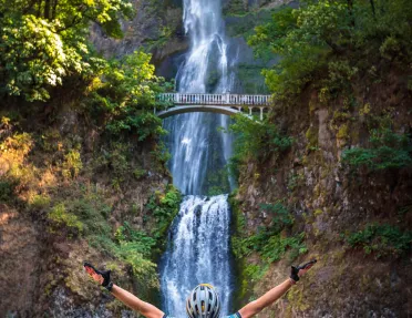 Guest in foreground, Multnomah Falls in background.