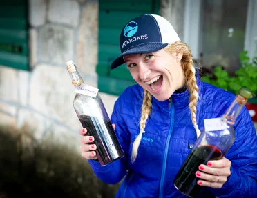 Leader with wine bottles, smiling at camera.