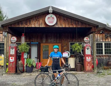Guest with bike standing in front of "THE APPLE STATION".