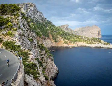 Biker riding around a bend on the coast of Mallorca.