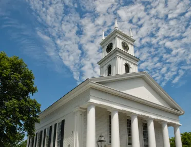 White colonial building with small clock tower.