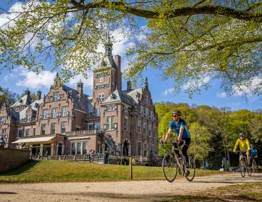 guests biking past beautiful building