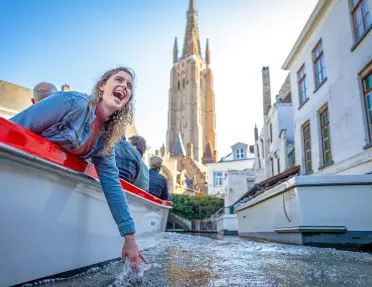 Guest dipping hand in water on boat