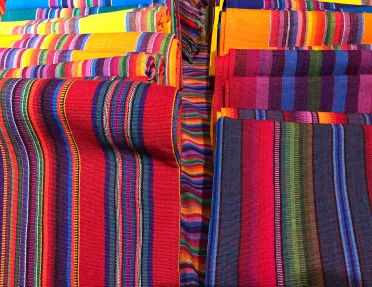 Colorful woven blankets rolled up