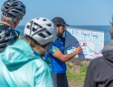 Guests receiving D5 leader brief, ocean in background.