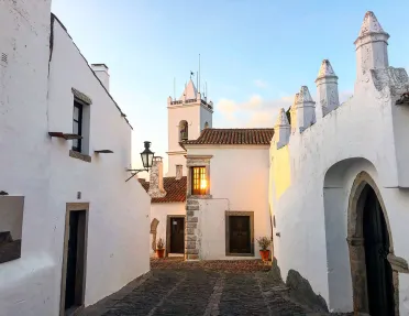 Walkway shot of white walled village during sunset.