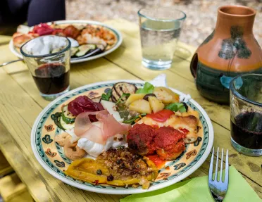 Platter of food, cheese, cured meats, meatballs, fruits, etc.