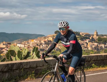 Guest cycling past mountaintop city.