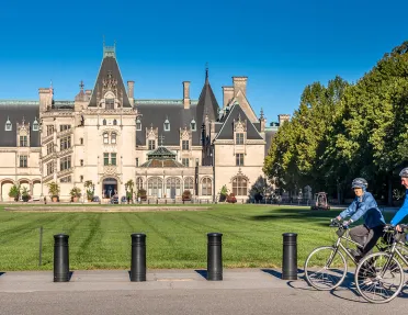 Guests biking in front of the Biltmore Estate.