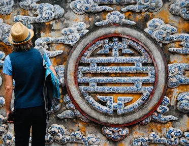 Guest in front of large painted longevity symbol.