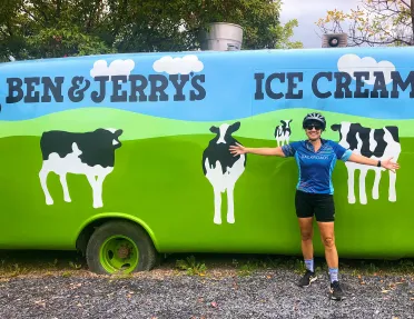Guest posing in front of Ben & Jerry's car.