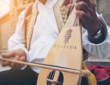 Close-up of local playing string instrument.