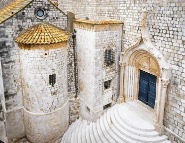 Shot of white stone buildings, staircase, doorway, etc.