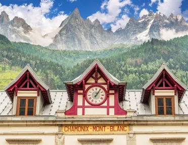 Train station clock at Chamonix Mont-Blanc, mountain in distance.