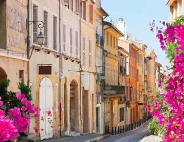 European alleyway lined with blooming bougainvillea flowers.