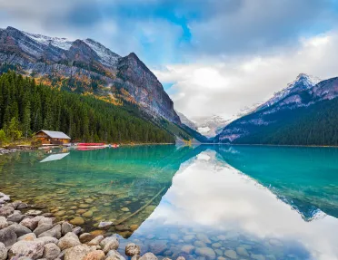 Large lake vista, wooden shack, mountains in background.