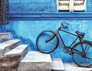 Bike sitting on the stairs against a blue wall