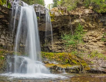 Shot of waterfall flowing into small lake.