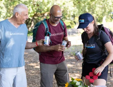 Three guests around lunch table, beers in hand.