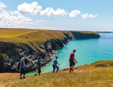 Four hikers walking up a hill in Cornwall, England