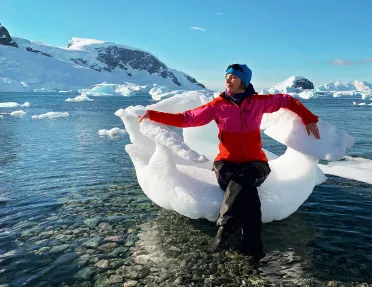 Woman sitting in a large piece of ice in Antarctica