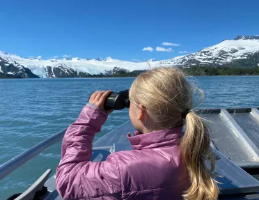 Child with binoculars on boat