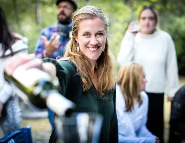 Point of view shot of woman pouring wine in a (your) glass.