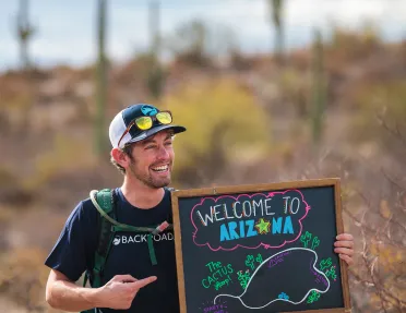 Leader holding a welcome to Arizona sign