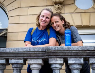 Two guests on stone balcony.