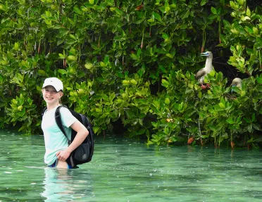 Woman wading in waste=deep water in Ecuador