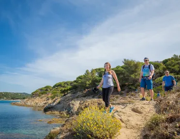 Group of three Backroads guests hiking beside the sea in France