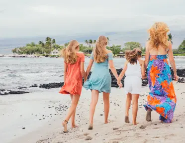 Mother a daughters walking along the beach in Hawaii