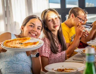 Teenagers eating handmade pizza in Portugal