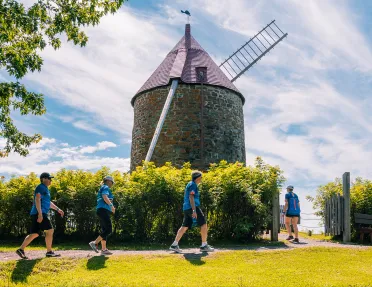 Four guests walking up towards windmill.