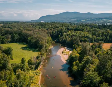 Bird's eye shot of a large river, kayaking guests are visible below.