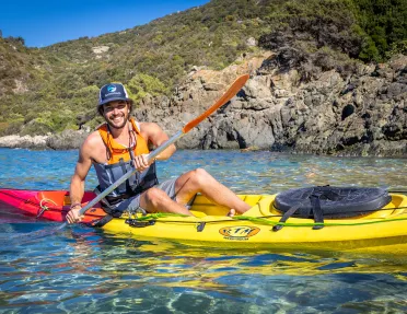 Man in a yellow kayak laughing 
