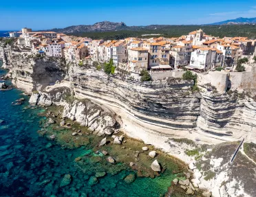 Wide shot of Corsican coastline. Houses dotting the hillside.
