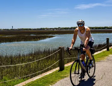 Guest cycling past grassy bog.
