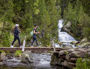 Hiking across a bridge with a waterfall in the background