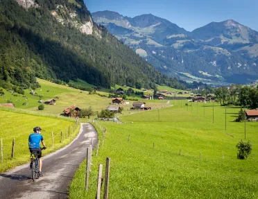 Guest cycling towards mountain village.