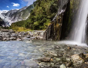 Waterfall flowing into a crystal clear river
