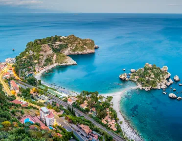 Bird's eye shot of colorful Italian coastline. Blue water and multi-colored houses.